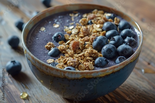 a bowl filled with blueberries and granola on top of a wooden table