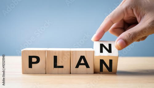 A hand is putting a block on top of a block that says Plan