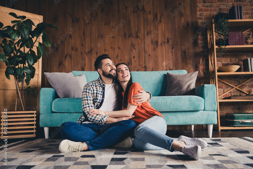 Obraz premium Full size photo of happy young couple sit floor look empty space hug move new place live together apartment room light house flat indoor