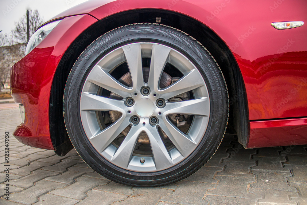 Gray rim of a red car wheel close-up
Gray rim of a red car wheel close-up