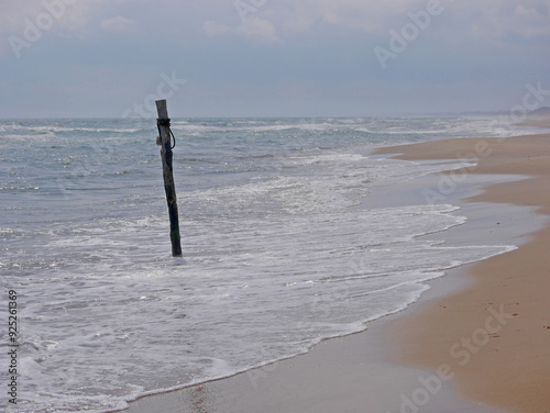 A stick to which boats are tied in the sea on the Skagen beach, Denmark photo