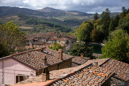 Panoramic view over the roofs of the village with the background of the colors of the woods and the Peschiera di S.Fiora, Santa Fiora, Grosseto, Tuscany, Italy photo