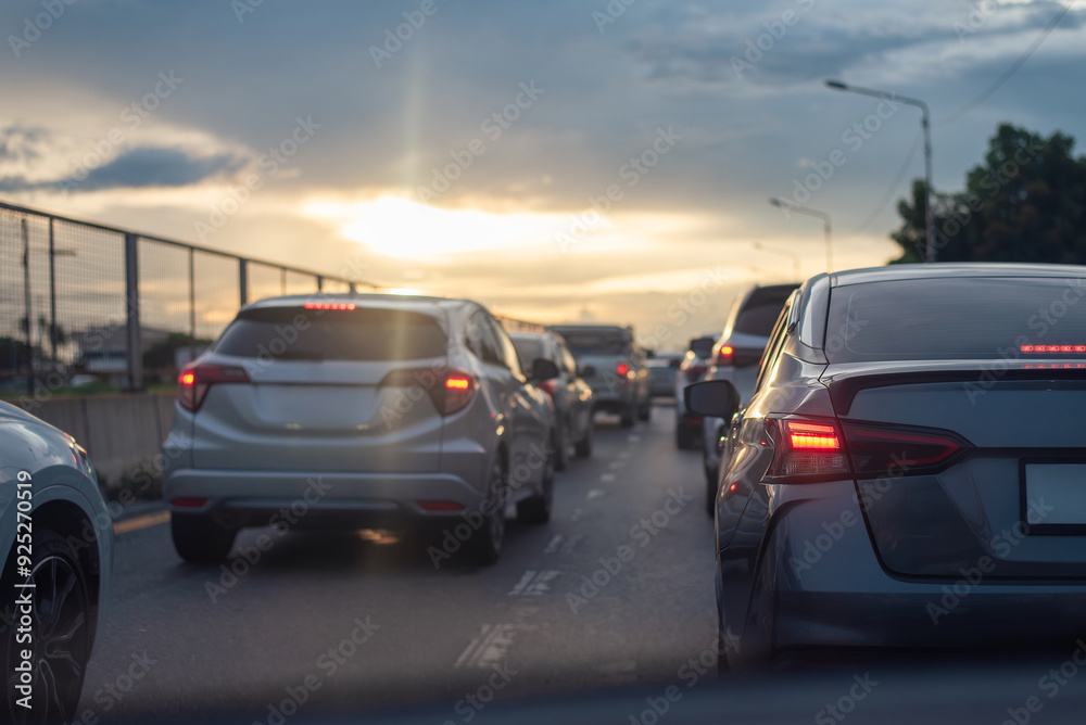 Cars stuck in traffic on a city highway during sunset, with brake lights glowing under a cloudy sky, creating a moody atmosphere. Cars stuck in traffic on a city highway during sunset, with brake lights glowing under a cloudy sky, creating a moody atmosphere.