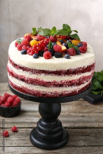 Tasty sponge cake with different fruits and mint on wooden table