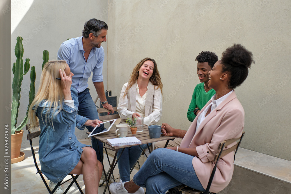 Fototapeta premium Content diverse coworkers laughing during break on terrace