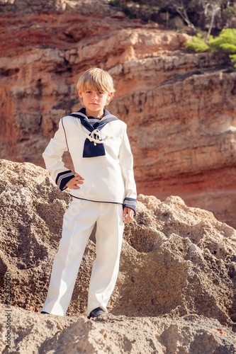 фотографія Kid in marine outfit standing on rocky cliff