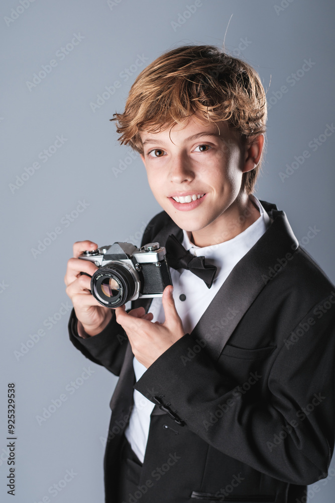 Preteen boy in elegant formal suit with bow tie and photo camera Preteen boy in elegant formal suit with bow tie and photo camera