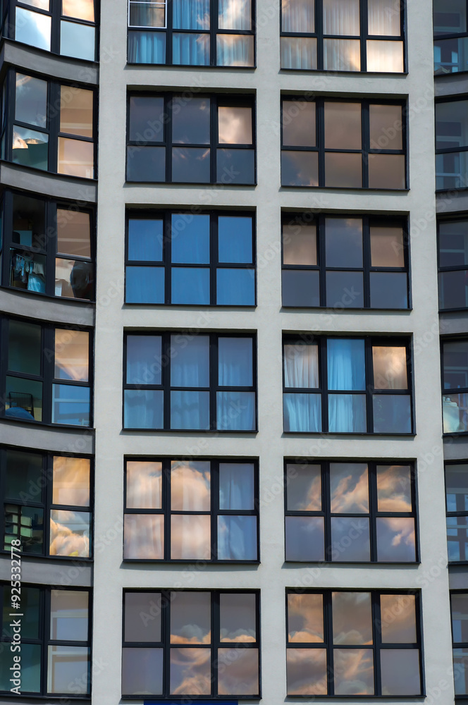 Windows with Black Casements on Facade of Modern Building. Sky Reflections in Windows Glass. Windows with Black Casements on Facade of Modern Building. Sky Reflections in Windows Glass.