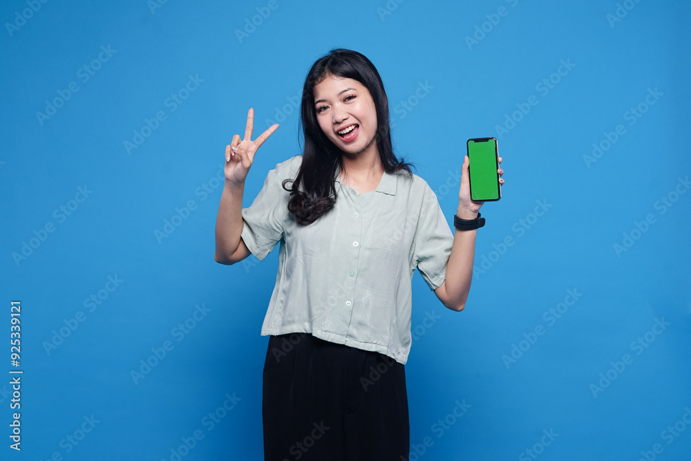 a woman holding up a phone with greenscreen that says peace on blue background a woman holding up a phone with greenscreen that says peace on blue background