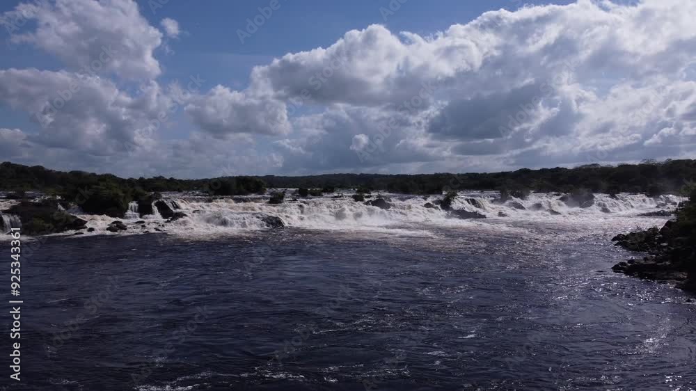 The static aerial shot, with a leftward pan, reveals the color palette of the Caroní River, from crystal-clear waters to ochre rocks battered by its waves The static aerial shot, with a leftward pan, reveals the color palette of the Caroní River, from crystal-clear waters to ochre rocks battered by its waves