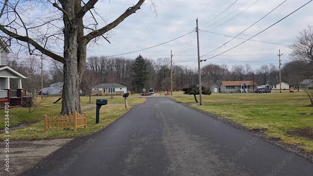 A quiet suburban street with houses, trees, and power lines. The peaceful atmosphere of the neighborhood is captured on a calm morning. A quiet suburban street with houses, trees, and power lines. The peaceful atmosphere of the neighborhood is captured on a calm morning.
