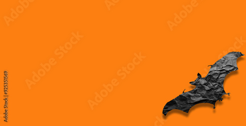 bat made of yat black paper on an orange background
