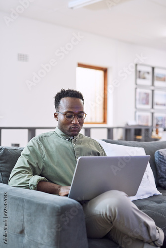 Black man, working and laptop in office as employee or web designer in digital agency. Male person, technology and reading with email, project and portfolio for creativity, career and online business