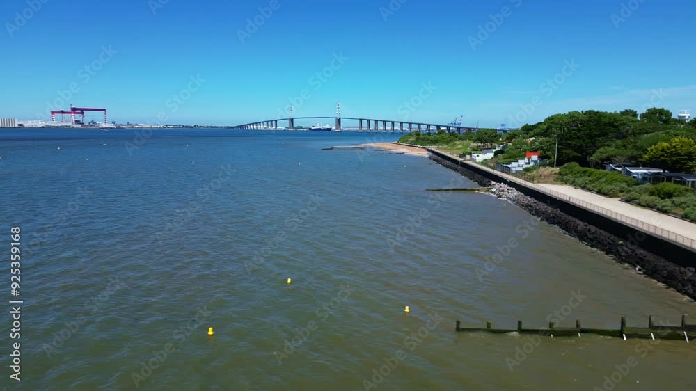 Skeleton beach with the Saint-Nazaire bridge in the background, France. Aerial drone sideways