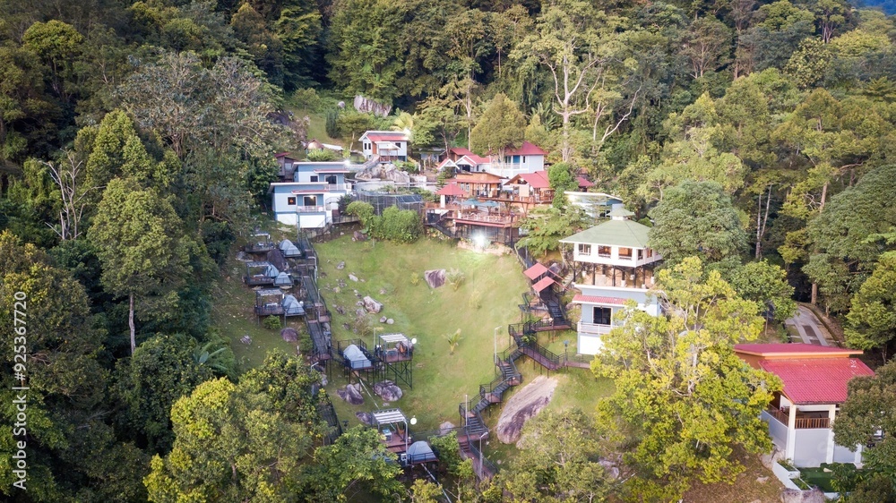 A view from above of a resort on a hill surrounded by forest and lots of greenery. A view from above of a resort on a hill surrounded by forest and lots of greenery.