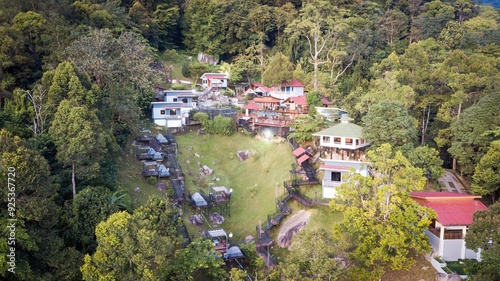 A view from above of a resort on a hill surrounded by forest and lots of greenery.