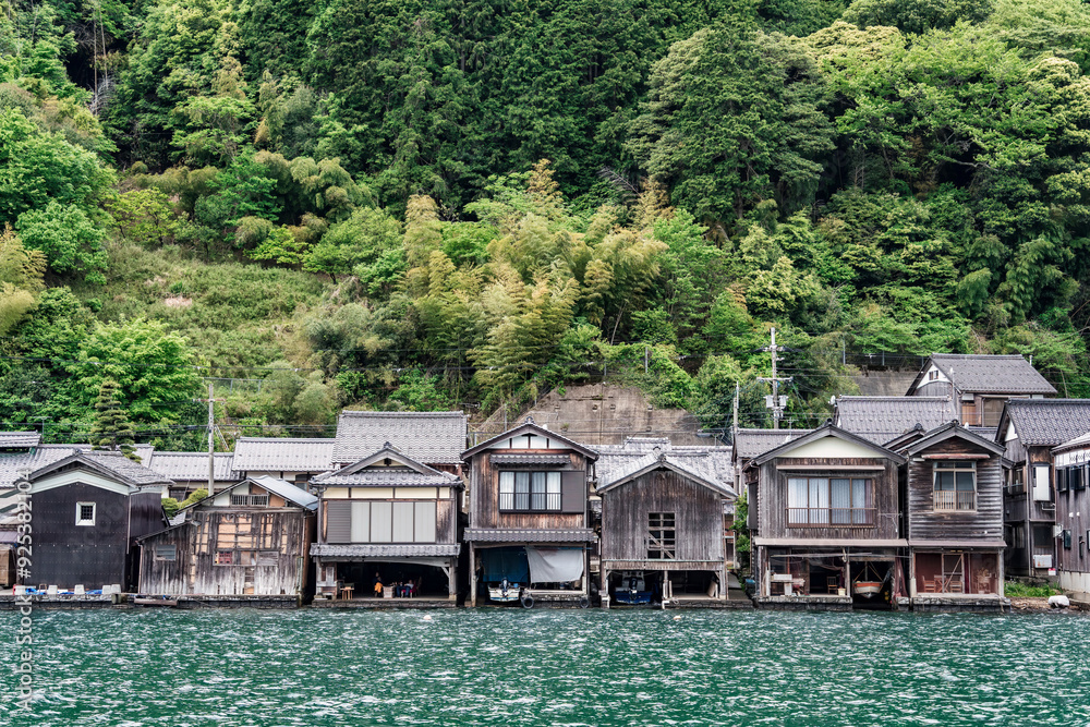 Fototapeta premium Beautiful scenic view with the wooden traditional waterfront boat houses called funaya around Ine Bay, in the village Ine, Japan