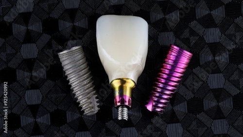 Beautiful composion on different dental implants replica and present with ceramic crown, top view on textured background photo