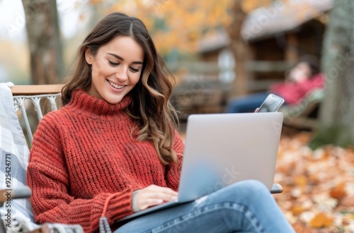 Young Woman Working on Laptop Outdoors During Autumn Sunshine
