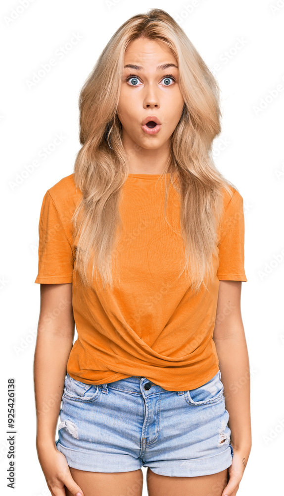 Fototapeta premium Young blonde girl wearing casual clothes scared and amazed with open mouth for surprise, disbelief face