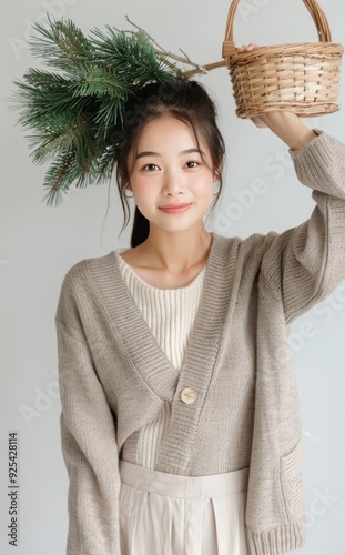 Woman Holding Miniature Christmas Tree and Gift Near Festive Decoration