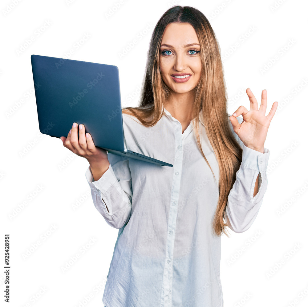 Beautiful caucasian woman working using computer laptop doing ok sign with fingers, smiling friendly gesturing excellent symbol Beautiful caucasian woman working using computer laptop doing ok sign with fingers, smiling friendly gesturing excellent symbol