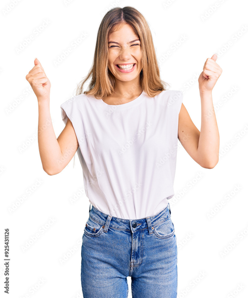 Beautiful caucasian woman with blonde hair wearing casual white tshirt celebrating surprised and amazed for success with arms raised and open eyes. winner concept. Beautiful caucasian woman with blonde hair wearing casual white tshirt celebrating surprised and amazed for success with arms raised and open eyes. winner concept.