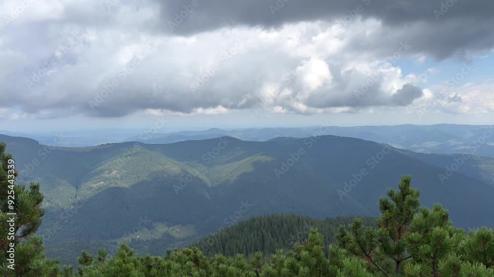 Clouds are moving over a mountain range on a partly cloudy day Clouds are moving over a mountain range on a partly cloudy day