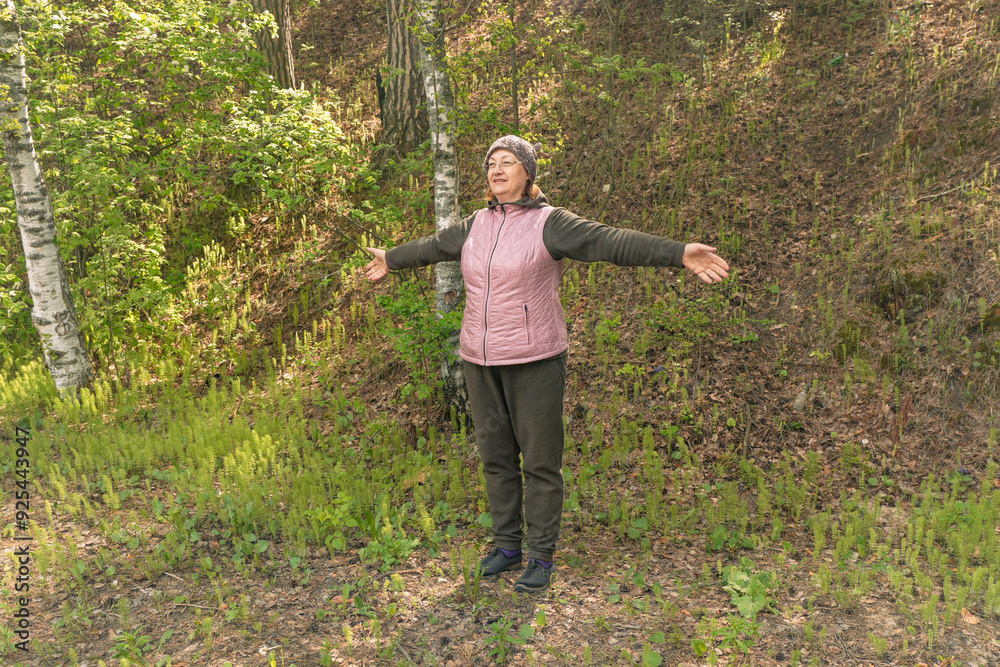 Person standing with arms open in a lush green forest during daylight Person standing with arms open in a lush green forest during daylight