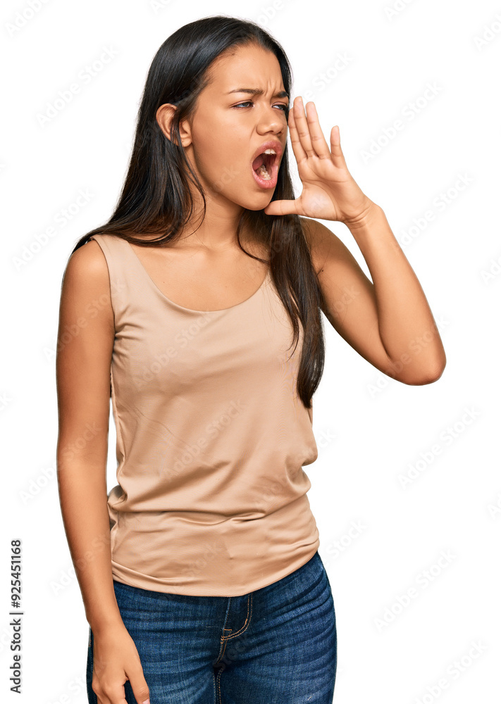 Beautiful hispanic woman wearing casual clothes shouting and screaming loud to side with hand on mouth. communication concept. Beautiful hispanic woman wearing casual clothes shouting and screaming loud to side with hand on mouth. communication concept.