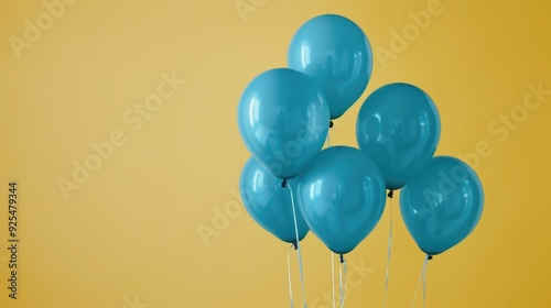 Group of teal helium balloons floating in the air against yellow wall background.