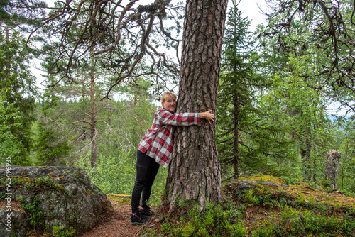 Woman hugging a tree in forest