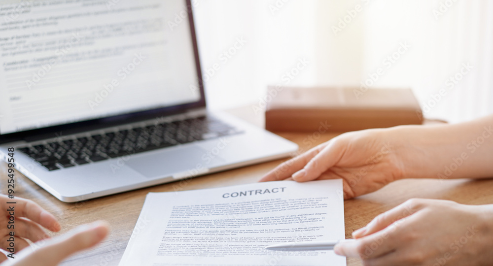 Obraz premium Businesswoman lawyer pointing into contract special points admitting something for colleague or client at the wooden desk in office. Business people teamwork and partnership, meeting concept