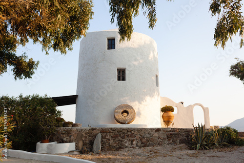 Traditional old white windmill on island Milos in Aegean sea photo