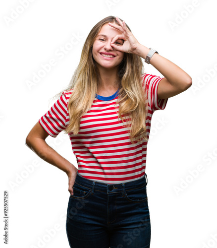 Young beautiful blonde woman over isolated background doing ok gesture with hand smiling, eye looking through fingers with happy face.