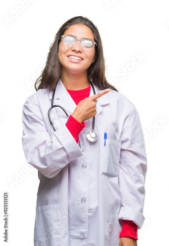 Young arab doctor woman over isolated background cheerful with a smile of face pointing with hand and finger up to the side with happy and natural expression on face looking at the camera. photo