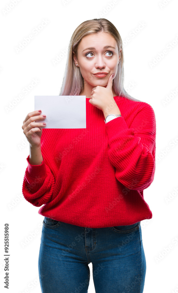Young blonde woman holding blank paper card over isolated background serious face thinking about question, very confused idea Young blonde woman holding blank paper card over isolated background serious face thinking about question, very confused idea