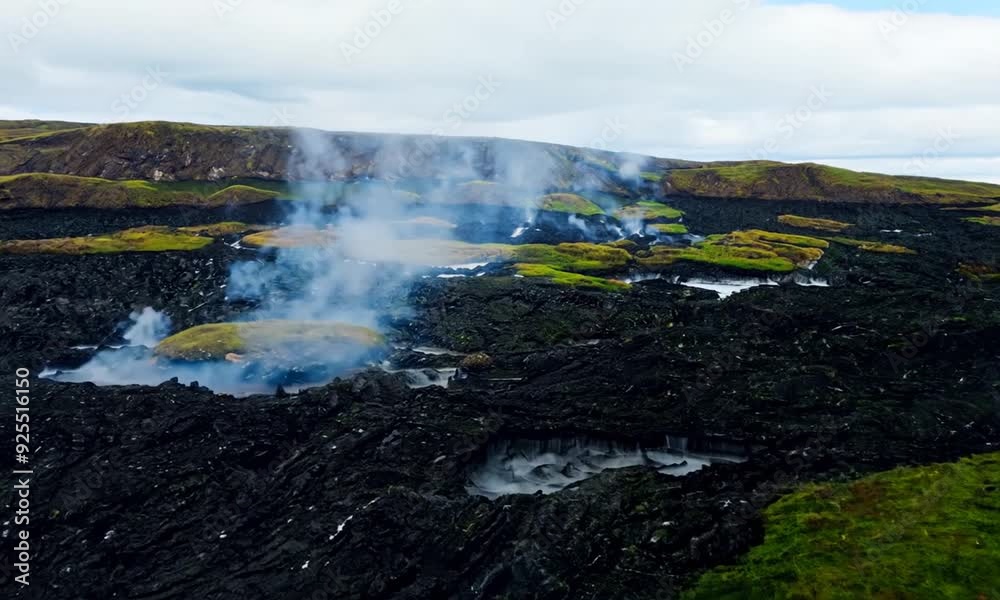 Drone shot of Iceland's volcanic landscape with steam rising from geothermal vents, capturing the raw beauty of black lava fields contrasted with vibrant moss. Drone shot of Iceland's volcanic landscape with steam rising from geothermal vents, capturing the raw beauty of black lava fields contrasted with vibrant moss.