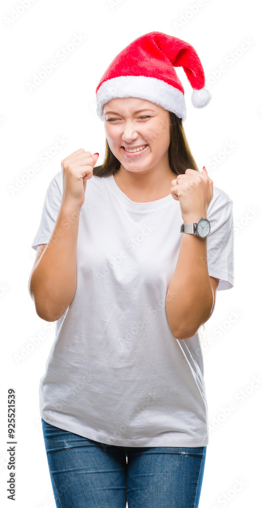 Young beautiful caucasian woman wearing christmas hat over isolated background very happy and excited doing winner gesture with arms raised, smiling and screaming for success. Celebration concept. Young beautiful caucasian woman wearing christmas hat over isolated background very happy and excited doing winner gesture with arms raised, smiling and screaming for success. Celebration concept.