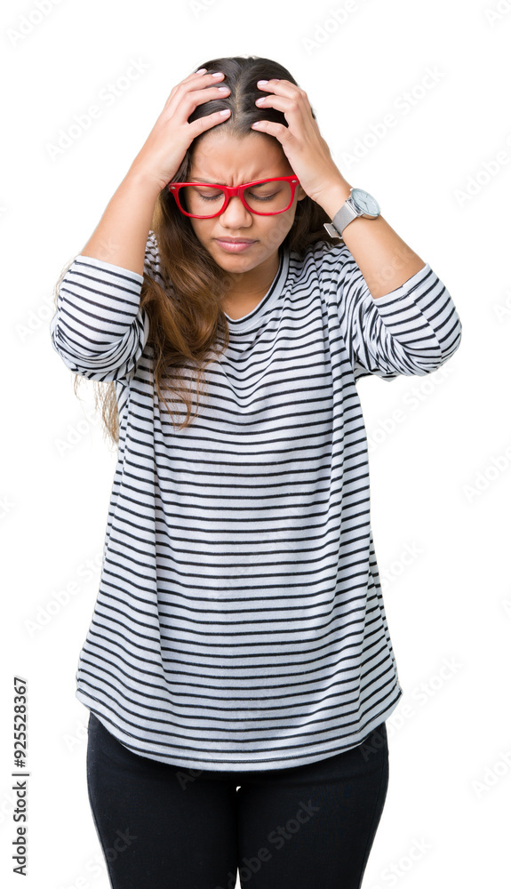Young beautiful brunette woman wearing stripes sweater and red glasses over isolated background suffering from headache desperate and stressed because pain and migraine. Hands on head. Young beautiful brunette woman wearing stripes sweater and red glasses over isolated background suffering from headache desperate and stressed because pain and migraine. Hands on head.