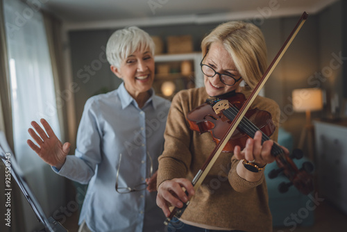 Private music teacher give violin lesson mature senior woman at home