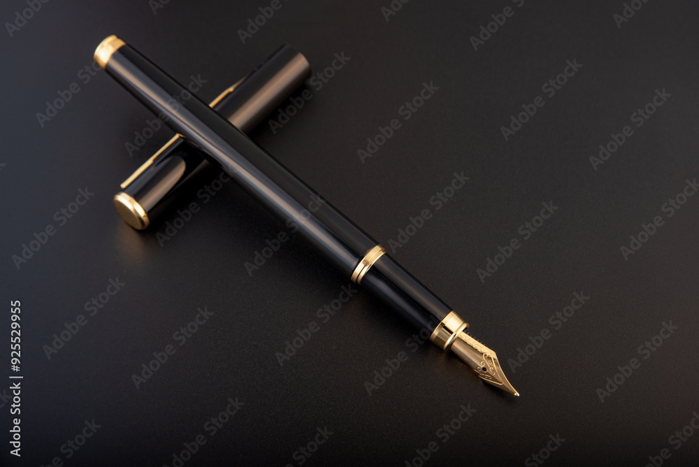 Fountain pen, beautiful black and gold fountain pen, positioned on dark background, selective focus. Fountain pen, beautiful black and gold fountain pen, positioned on dark background, selective focus.