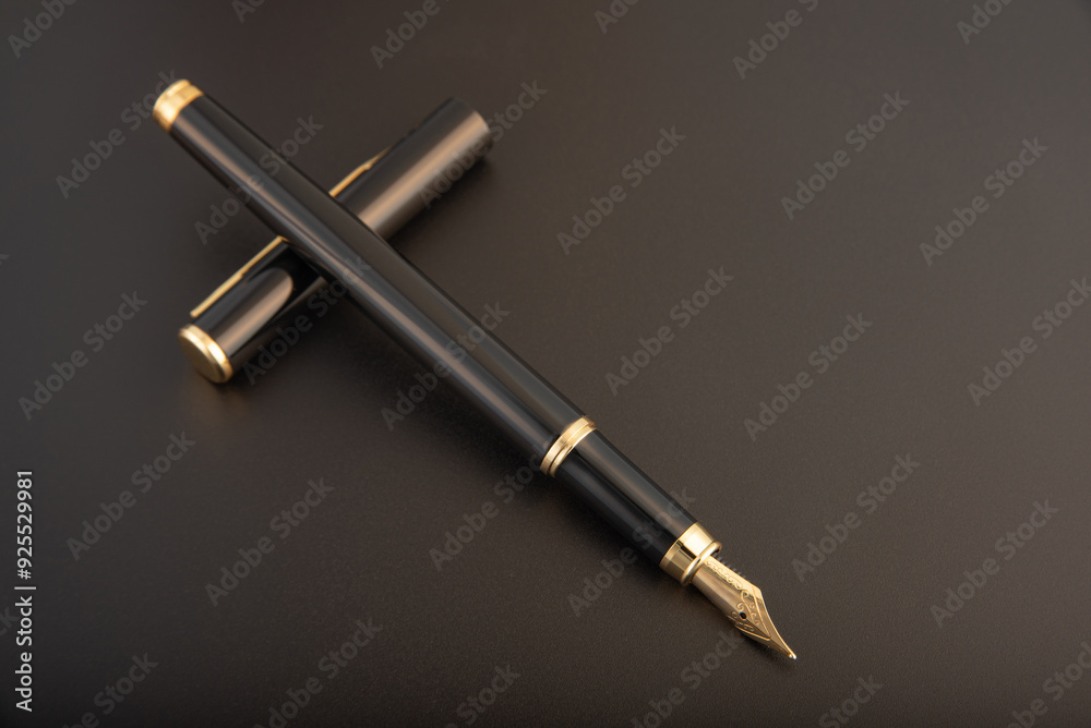 Naklejka premium Fountain pen, beautiful black and gold fountain pen, positioned on dark background, selective focus.