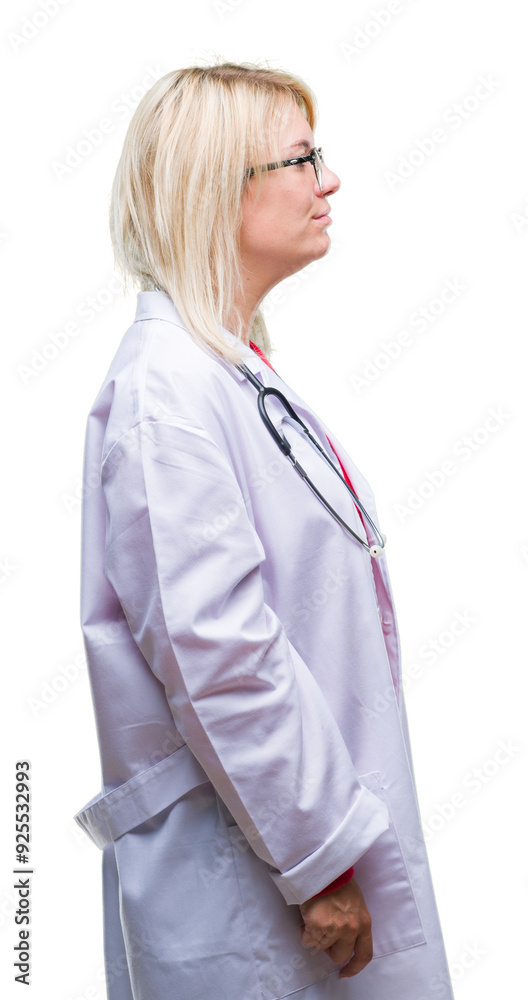 Young beautiful blonde doctor woman wearing medical uniform over isolated background looking to side, relax profile pose with natural face with confident smile. Young beautiful blonde doctor woman wearing medical uniform over isolated background looking to side, relax profile pose with natural face with confident smile.