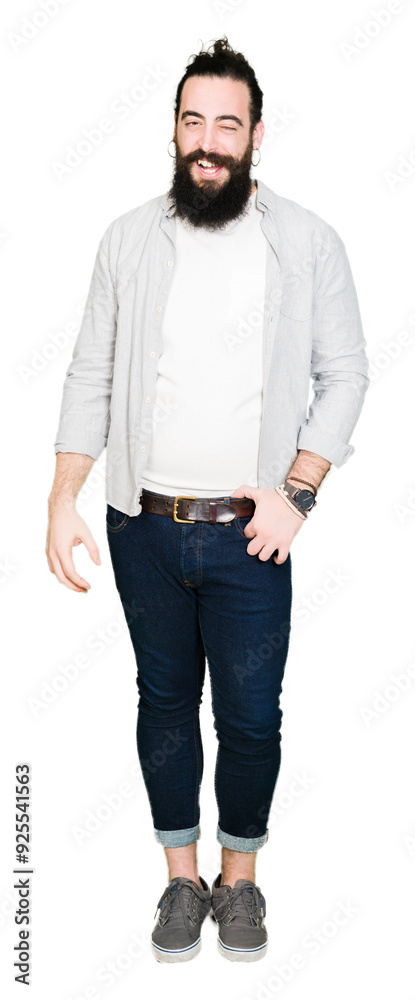 Young man with long hair, beard and earrings winking looking at the camera with sexy expression, cheerful and happy face. Young man with long hair, beard and earrings winking looking at the camera with sexy expression, cheerful and happy face.
