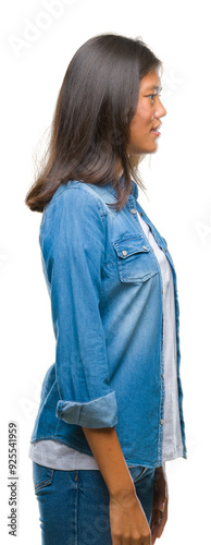 Young asian woman over isolated background looking to side, relax profile pose with natural face with confident smile.