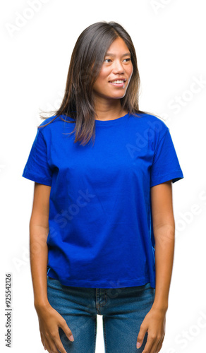 Young asian woman over isolated background looking away to side with smile on face, natural expression. Laughing confident.
