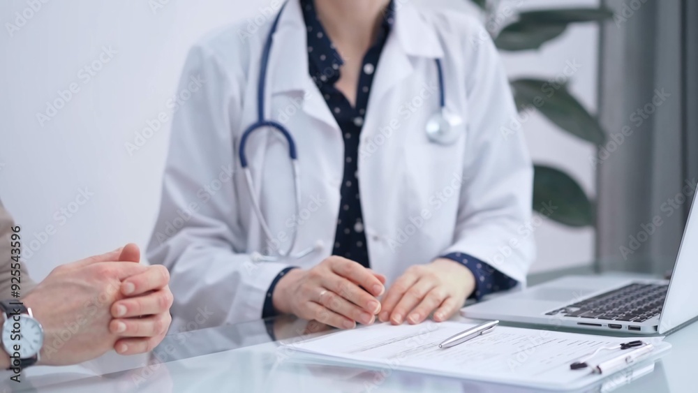 Doctor and patient are talking in clinic. Female physician is sitting and discussing test results with a senior man. Medicine and science Doctor and patient are talking in clinic. Female physician is sitting and discussing test results with a senior man. Medicine and science