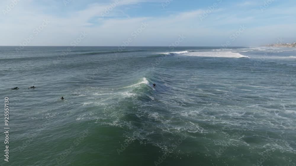 Aerial view of surfers in the Pacific Ocean at Swamis Beach catching waves on partly cloudy day at crowded famous surf spot Aerial view of surfers in the Pacific Ocean at Swamis Beach catching waves on partly cloudy day at crowded famous surf spot