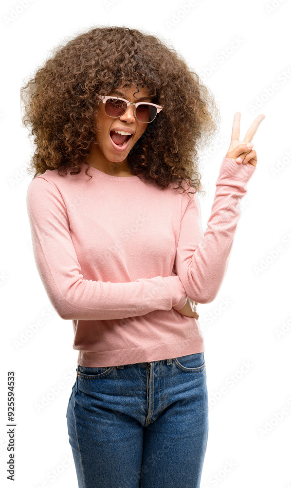 African american woman wearing pink sunglasses smiling with happy face winking at the camera doing victory sign. Number two. African american woman wearing pink sunglasses smiling with happy face winking at the camera doing victory sign. Number two.